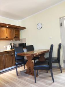 a kitchen with a wooden table and chairs at Maryla in Kołobrzeg +9 photos
