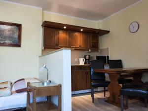 a kitchen and a living room with a desk and a table at Maryla in Kołobrzeg