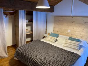 a bedroom with a large bed with a wooden headboard at A la croisée des chemins in Saint-Nicolas-des-Biefs