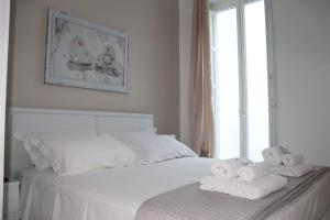 una camera da letto con un letto bianco e asciugamani di La Dolce Dimora a Fasano