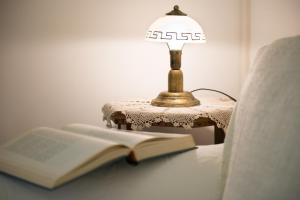 a lamp sitting on a table next to an open book at Antico Borgo Teresiano in Trieste