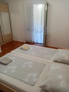 two beds in a room with a window at Apartments Anita Hure in Hvar