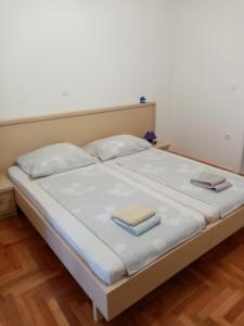 a large white bed with two books on it at Apartments Anita Hure in Hvar