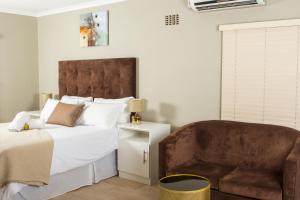 un dormitorio con una cama y una silla en 103onWallace Self Catering Guest House, en Ciudad del Cabo