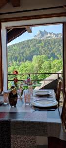 una mesa con vistas a una montaña a través de una ventana en Appartement T2 à BERNEX avec WiFi, vue sur montagne, en Bernex