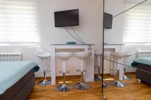 Habitación con cama y mesa con taburetes en Apartment SELF CHECK IN 00-24 MM, en Belgrado