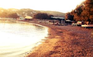 a beach with a group of buildings and the water at Filio Apartments in Kámbos