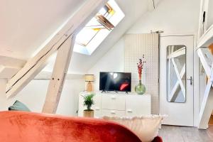 a living room with a red couch and a tv at Le Matisse in Bourges