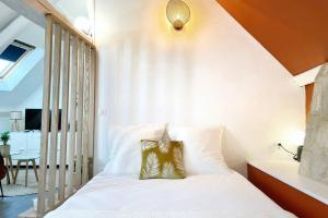 a bedroom with a white bed with a pillow on it at Le Matisse in Bourges