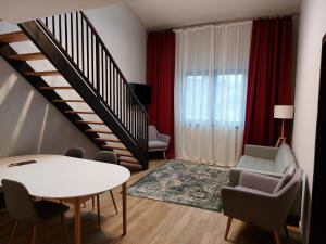 a living room with a staircase and a table and chairs at H11 Downtown Apartments in Târgu-Mureş