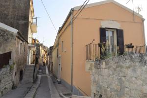 un callejón con un edificio y una pared de piedra en "Le Maioliche" casa tipica nel centro storico di Modica, en Módica