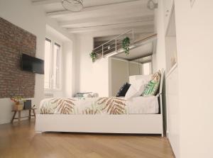 een witte slaapkamer met een bed en een spiegel bij P&D Apartments Darsena in Milaan