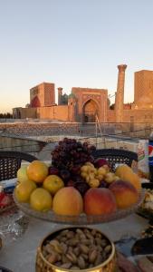 two plates of fruit on a table in front of a city at Hotel Minor in Samarkand