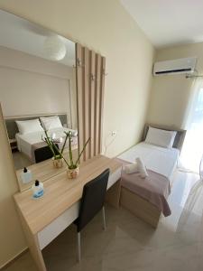 een kamer met 2 bedden, een bureau en een spiegel bij Elizabeth Apartments Himare in Himare