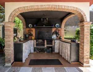 an outdoor kitchen with an archway and a brick oven at Vivienda Turística Rural Mari Carmen in Baeza