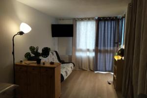 a living room with a couch and a window at Appartement 604 avec vue sur la vallée de la Cerdagne in Font-Romeu-Odeillo-Via