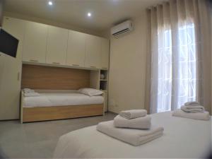 1 dormitorio con 2 camas y toallas. en "Le Maioliche" casa tipica nel centro storico di Modica, en Módica