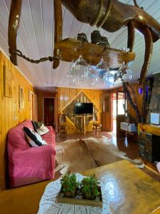 Recanto do També في أوروبيسي: غرفة معيشة مع أريكة وردية وتلفزيون