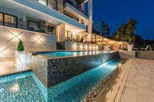 a swimming pool in front of a house at night at Dollaku Apartments in Bar