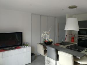 a kitchen with a table with chairs and a television at Gîte La Lancieutine Proche Plages 4 Personnes in Lancieux