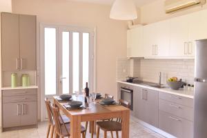 una cucina con tavolo e sedie e una cucina con armadietti bianchi di Arodo a Città di Lefkada