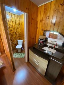 a bathroom with a toilet and a sink and a mirror at Recanto do També in Urubici