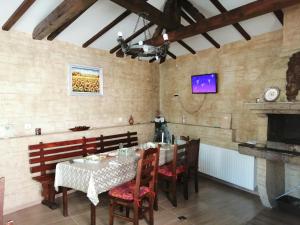 a dining room with a table and chairs and a fireplace at Dariya Guest House in Sapareva Banya