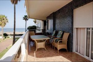 a balcony with a table and chairs and the ocean at Pez Espada 1ª Línea Playa y Parking Incluido in Torremolinos