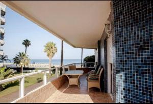 a balcony with a table and chairs and the beach at Pez Espada 1ª Línea Playa y Parking Incluido in Torremolinos