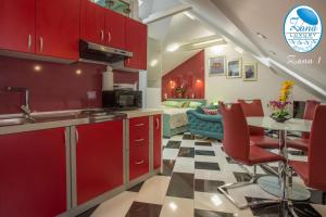 a kitchen with red cabinets and a table with chairs at Zana Luxury Studios Split center in Split