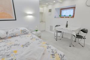 a bedroom with a bed and a desk and a table at Apartment light in Pula in Pula