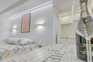 a bottle of wine sitting on a table in a bedroom at Apartment light in Pula in Pula