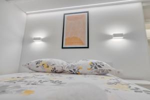 a bed with two pillows and a picture on the wall at Apartment light in Pula in Pula