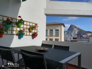 una mesa en un balcón con vistas a la montaña en Ático Galileo, en La Línea de la Concepción