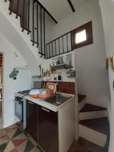 a small kitchen with a sink and a staircase at Casetta Miracoli Salento in Tuglie +12 photos