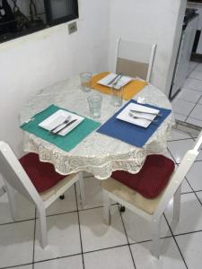 a table with a white table cloth and two chairs at Quarto INDIVIDUAL Casa Super Aconchegante WIFI 350 MEGA in Osasco
