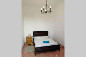 a small bedroom with a bed and a chandelier at Ses Venes 1 in Maria de la Salut