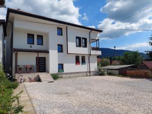 ein weißes Haus mit Kieseinfahrt in der Unterkunft Residence Lubina in Sarajevo