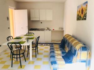 ein Wohnzimmer mit einem Tisch, Stühlen und einem Sofa in der Unterkunft Marasusa - Il Giardino dei Sogni in Parghelia