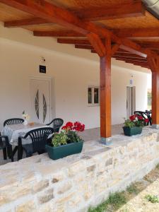 a patio with a table and chairs and a stone wall at Apartmani Dejan in Skradin