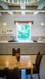 a kitchen with a wooden table and chairs at Apartment near the river with it's own entrance in Līgatne