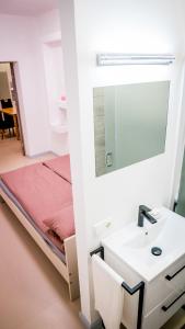 a bathroom with a white sink and a bed at Apartment near the river with it's own entrance in Līgatne