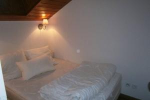 a bed with white sheets and pillows in a room at Appartement duplex 7 pers 3 chambres pied des pistes La Joue du Loup in Le Dévoluy +27 photos