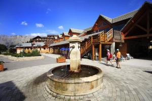a fountain in a courtyard in front of a lodge at Appartement duplex 7 pers 3 chambres pied des pistes La Joue du Loup in Le Dévoluy