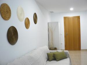 ein Wohnzimmer mit einem weißen Sofa und einigen Platten an der Wand in der Unterkunft PISO CENTRICO EN BENICARLO 2 in Benicarló