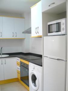 cocina con armarios blancos, lavadora y secadora en PISO CENTRICO EN BENICARLO 2, en Benicarló