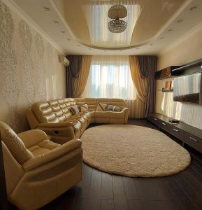 een grote woonkamer met een bank en een tapijt bij Просторные апартаменты in Kiev
