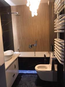 a bathroom with a toilet and a tub and a sink at Apartament Wrzeszcz, blisko morza in Gdańsk