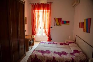 um quarto com uma cama e uma janela com cortinas vermelhas em Casa Vacanza da Tonino em Ischia