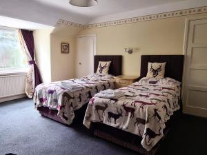 a bedroom with two beds and a window at West Craig Farm House in Forfar